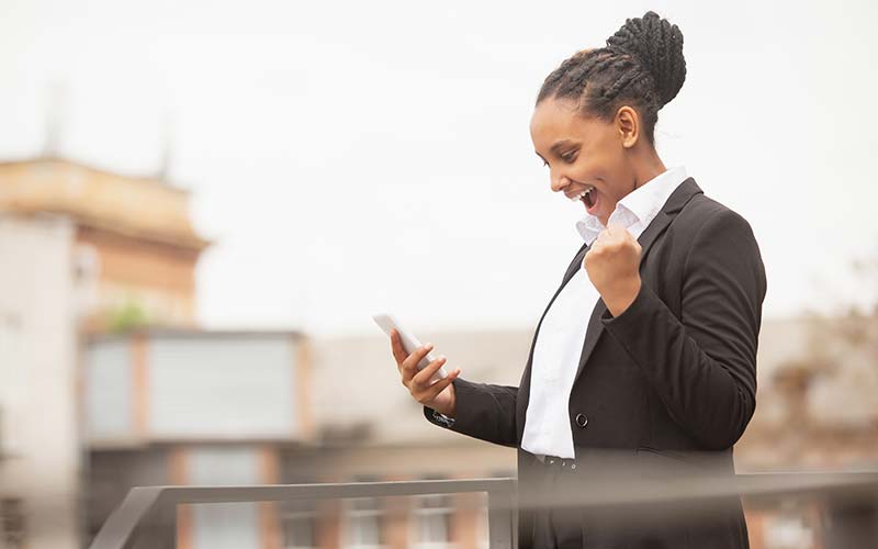 confident businesswoman getting an exciting phone text