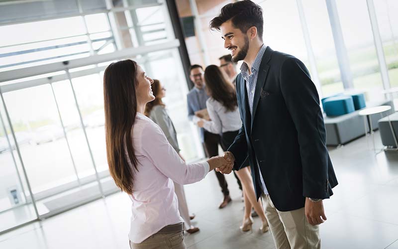 business colleagues shaking hands in business lobby